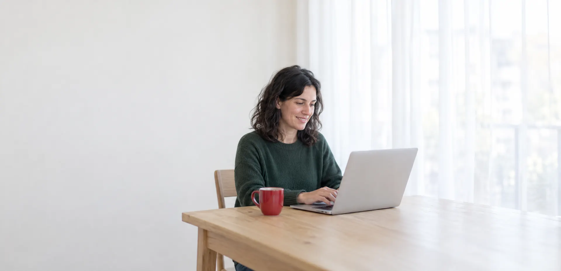 Mujer trabajando con una notebook en el escritorio de su casa