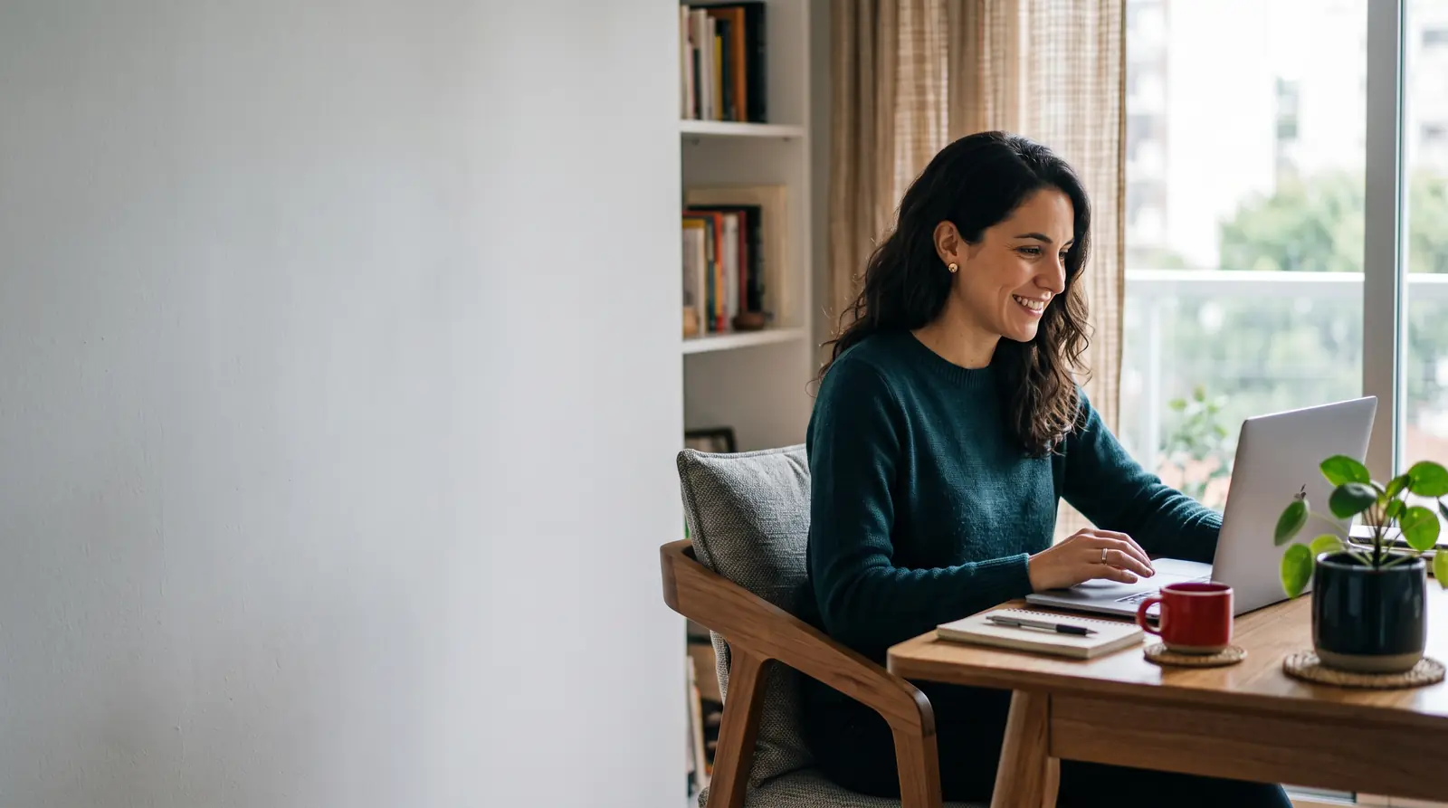 Mujer trabajando con una notebook en el escritorio de su casa